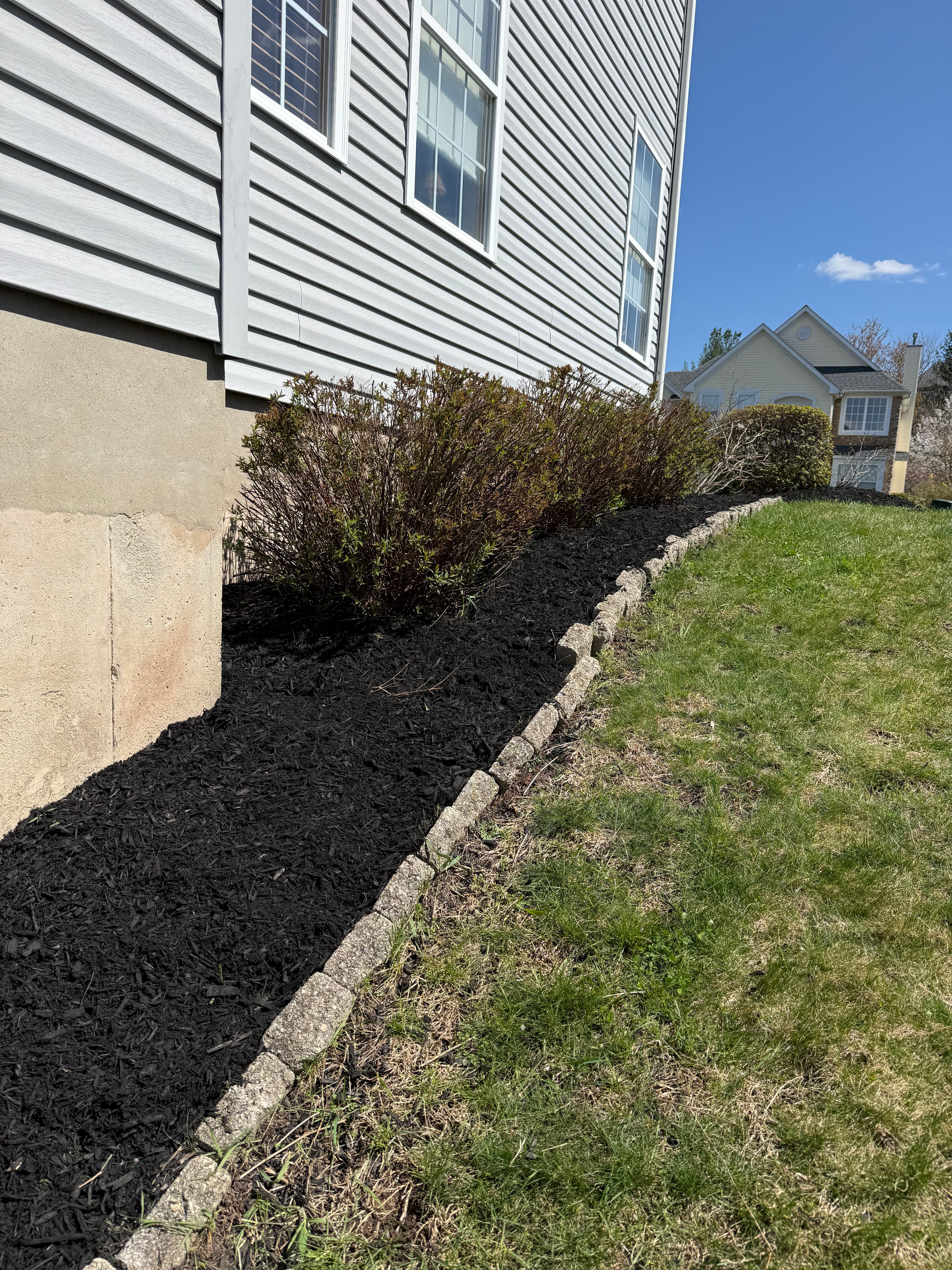 Fresh black mulch bed along house foundation